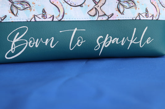 Detailaufnahme in Schönschrift Born to sparkle auf petrolfarbenem Kunstleder