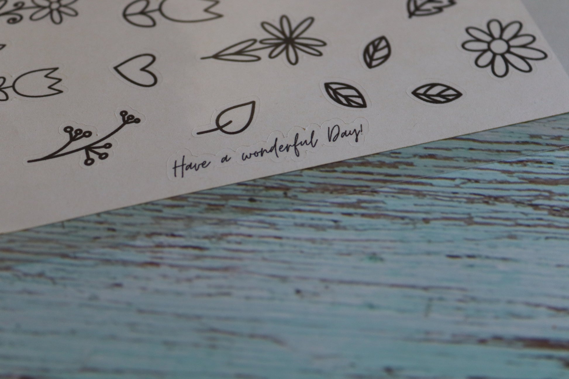 Detailaufnahme Detailaufnahme Stickerbogen. Verschiedene Blumen und Blätter mit einfacher Lineart. Am Rand steht der Spruch Have a wonderful Day