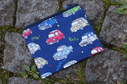 Handgenähtes Täschchen mit verschiedenen, einfarbigen Retro-Auto-Motiven und dunkelblauem Reißverschluss – ideal für Kleinigkeiten unterwegs.
